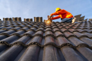A worker in a hard hat fixes a roof