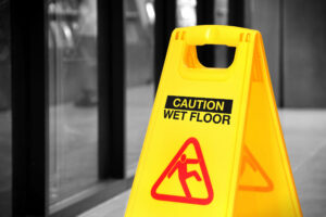 A wet floor sign is displayed in a hallway